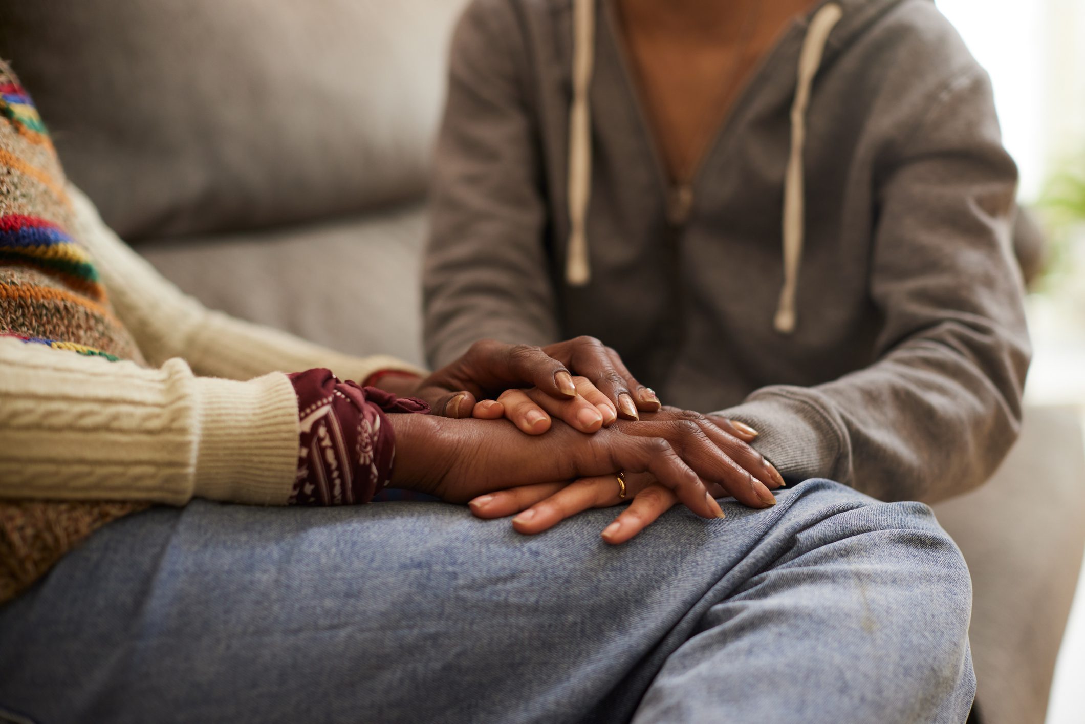 Two people holding hands in a comforting gesture.
