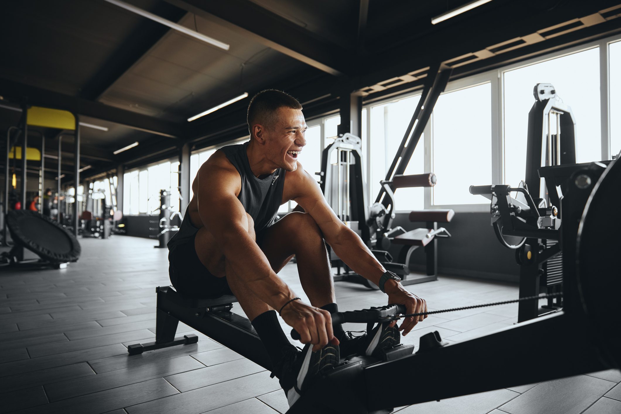 Man working out on a rowing machine in a gym.