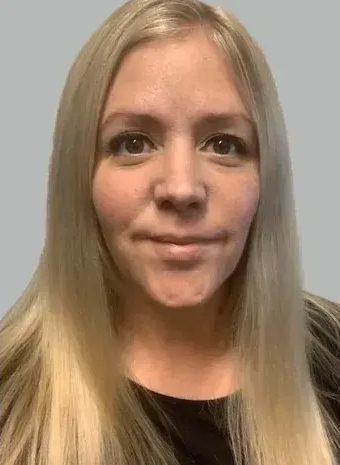 Woman with long blonde hair, neutral expression.