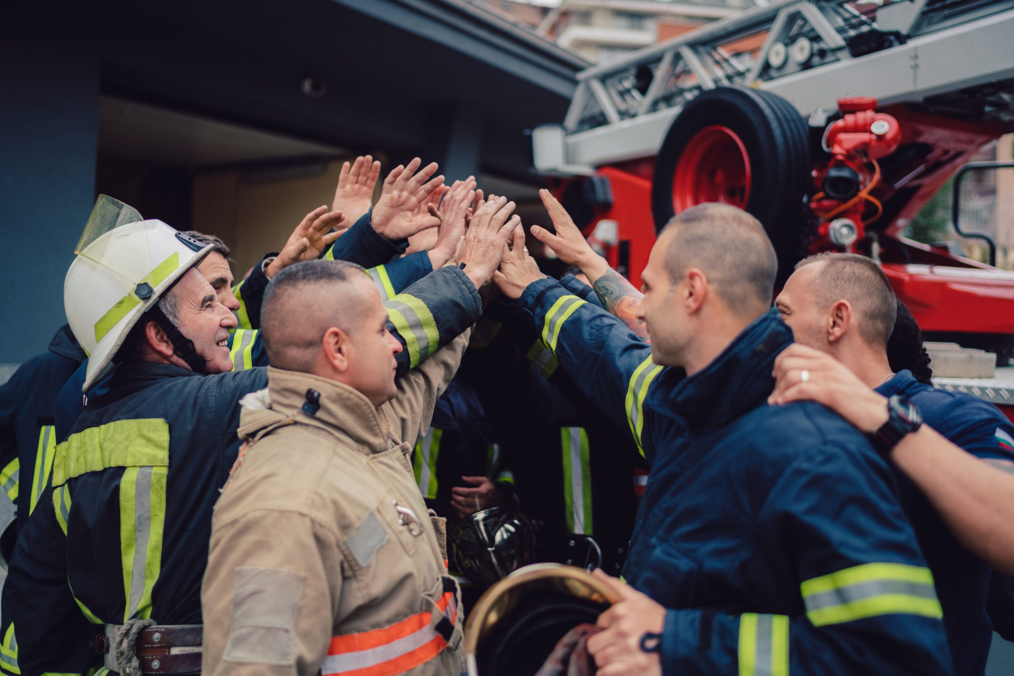 Firefighters sharing a celebratory high-five after a task.