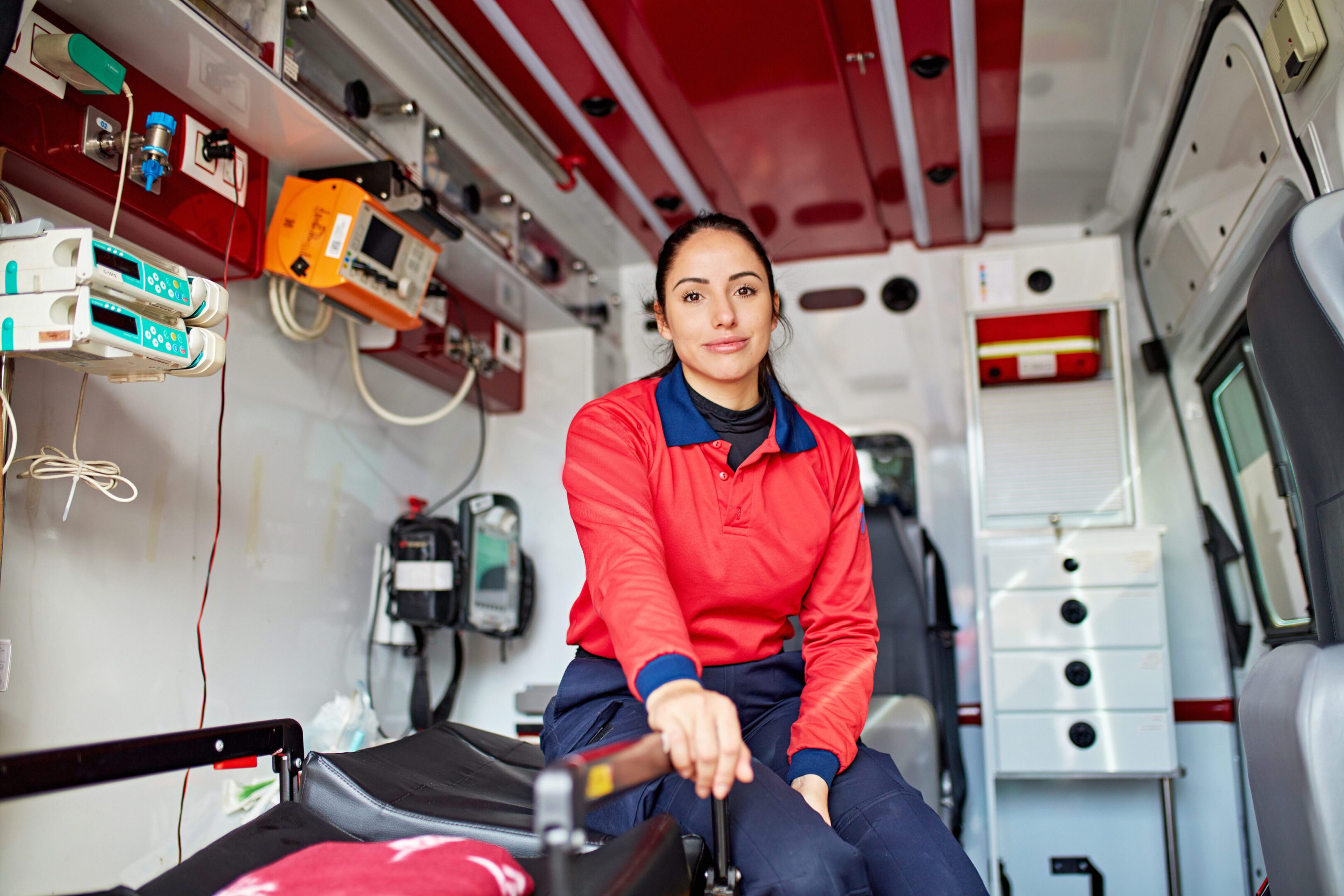 A paramedic sitting inside an ambulance, ready to assist.