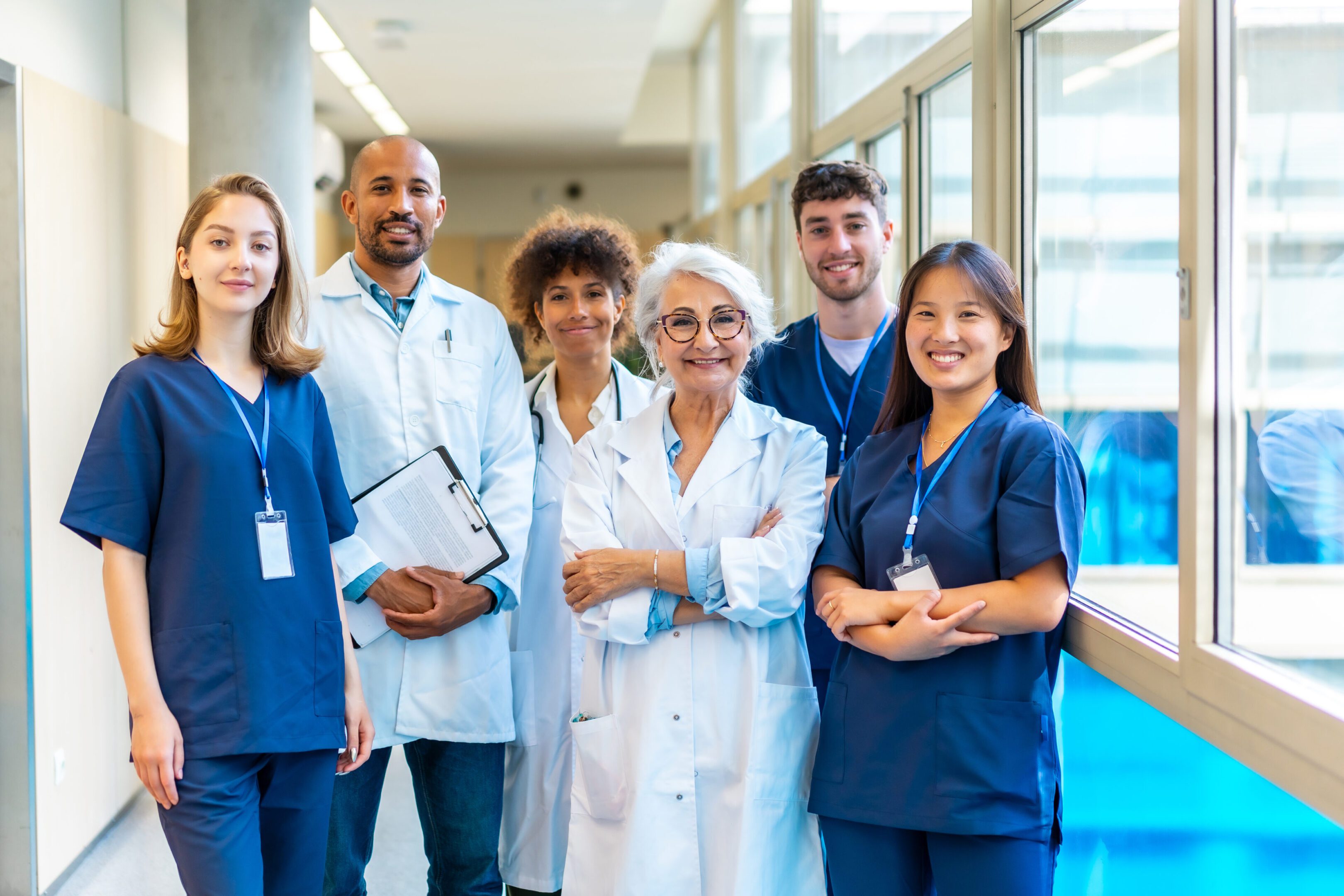 Diverse medical team posing confidently in hospital corridor.