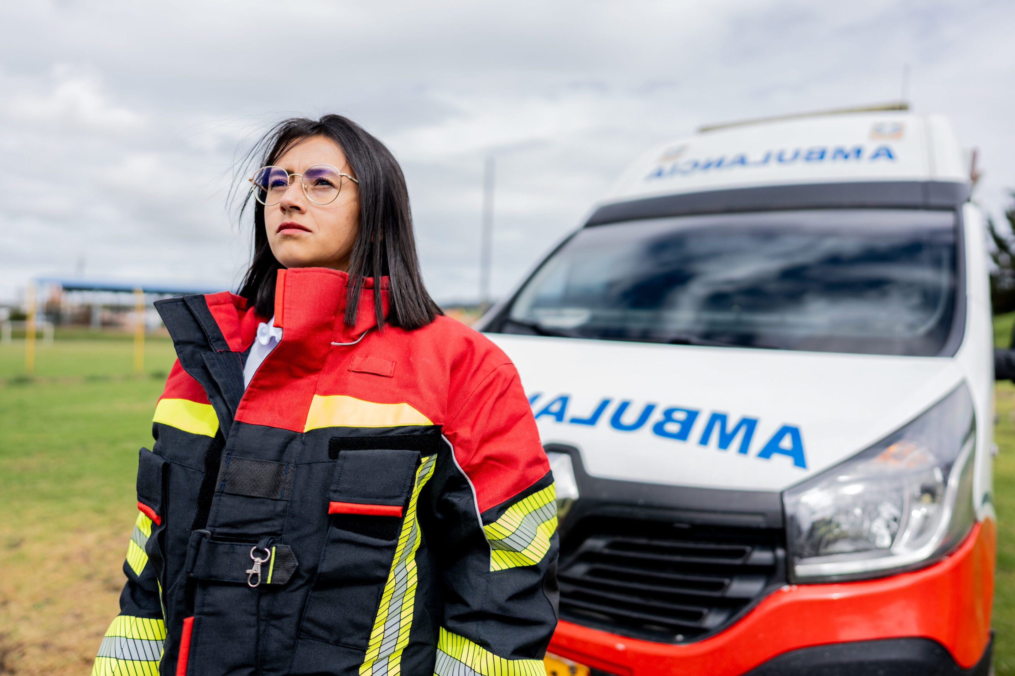 Emergency responder standing confidently in front of an ambulance.