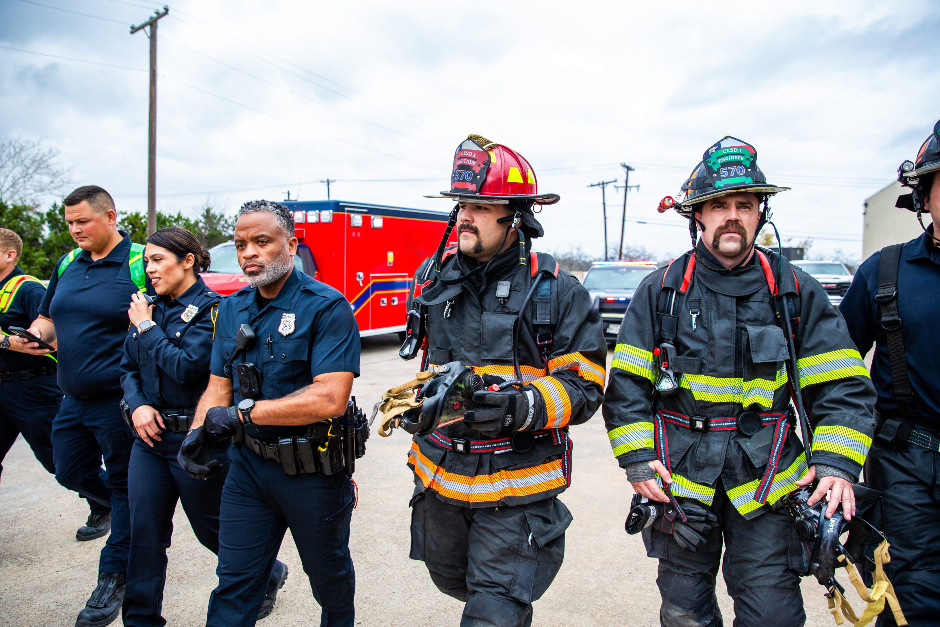 Two firefighters and two police officers standing outdoors.